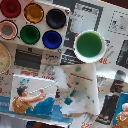 Tisch mit Wasserfarben und einer bemalten Gipsform