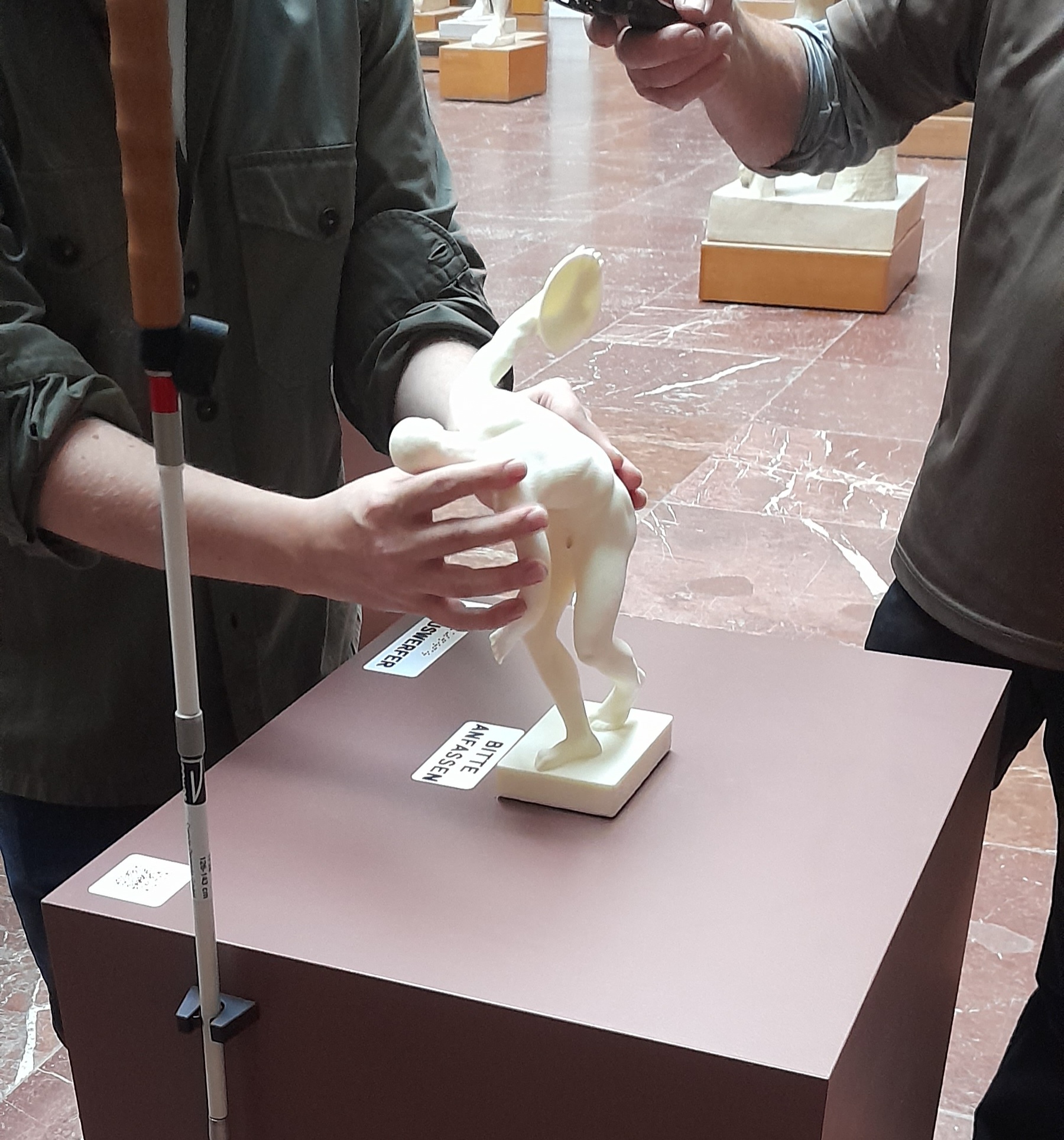 Eine Männerhand ertastet ein kleines Modell des Diskobol